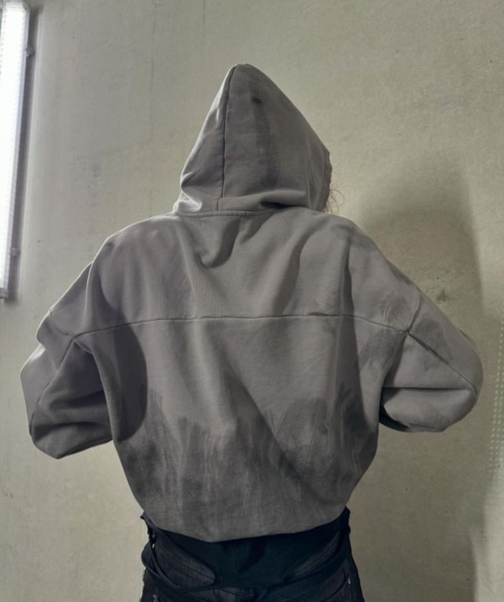 Szara bluza z widocznymi plamami na plecach – przykład zabrudzenia od wody lub tłuszczu, problem z czyszczeniem ubrań. Jak usunąć plamę?