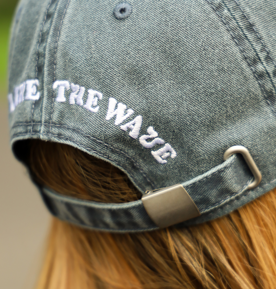 Zbliżenie na metalowe zapięcie regulacyjne w jeansowej czapce z daszkiem Highwave z haftem „High Like The Wave”