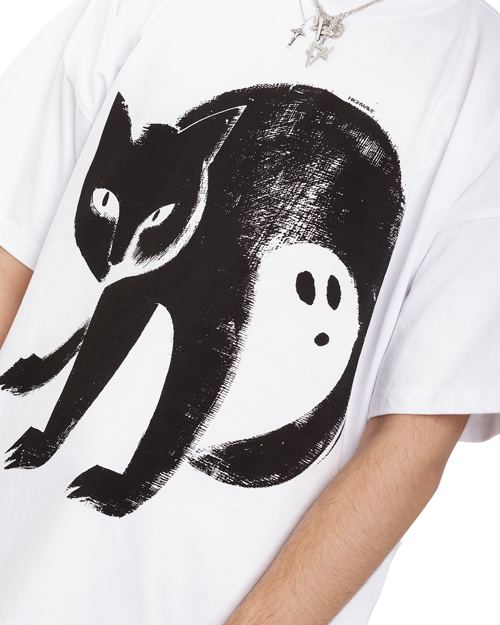 Bliskie ujęcie koszulki z kotem – biały t-shirt z czarną grafiką kota z ukrytym duchu w przestrzeni ogona. Widoczne detale nadruku.