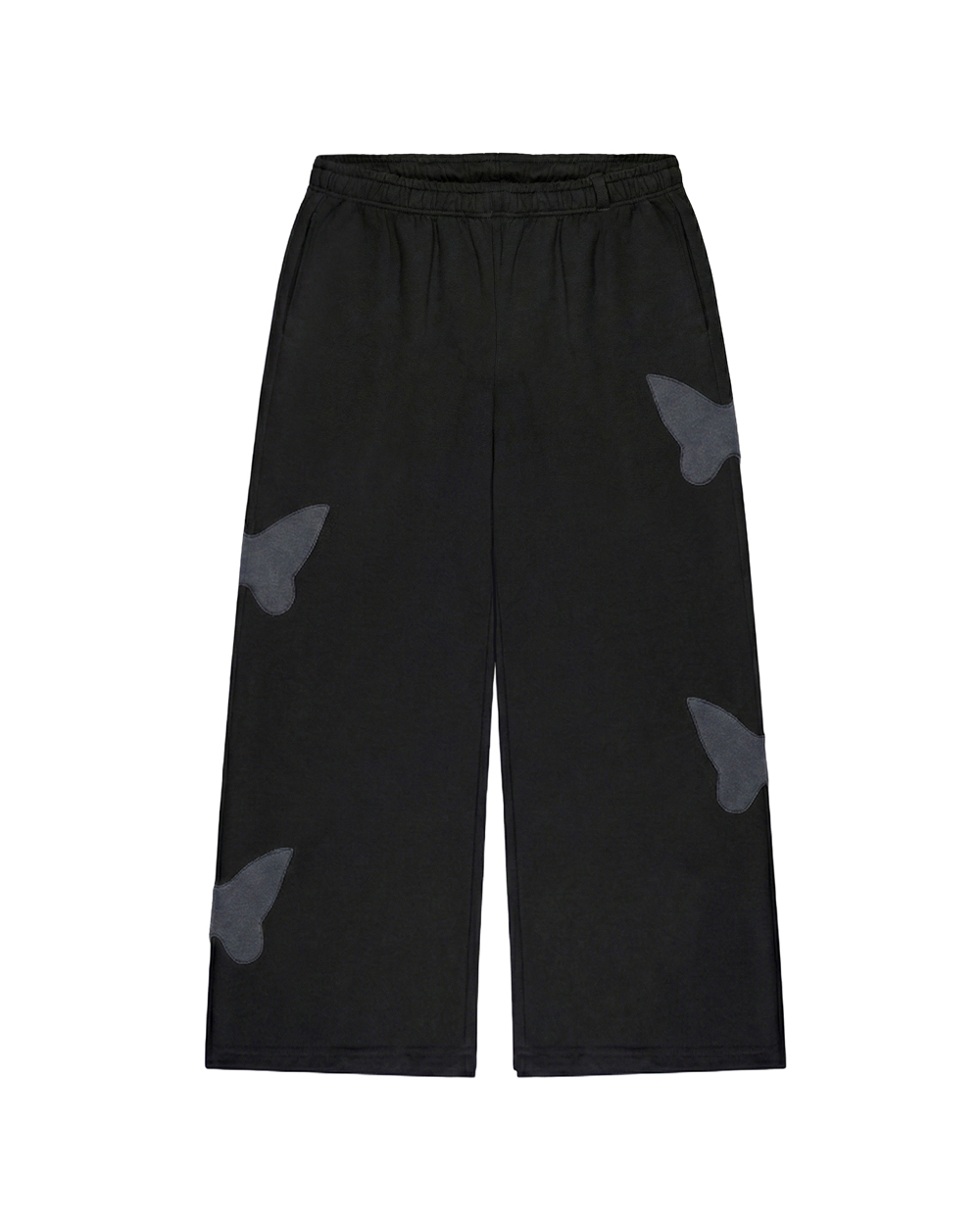 Czarne spodnie dresowe baggy z motywem motyli na nogawkach, luźny krój i szerokie nogawki na białym tle